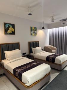 two beds in a hotel room with two beds at Hotel Royal Empire in Gandhinagar