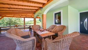 a patio with a wooden table and wicker chairs at Villa Magic by Villas Guide in Jalžabet