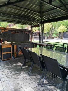 a glass table and chairs on a patio at Moravski konak- Moravian Inn in Ovčar Banja