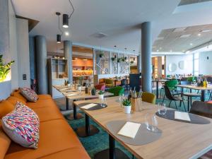 ein Restaurant mit Holztischen und -stühlen und einer Cafeteria in der Unterkunft Novotel Bourges in Bourges