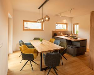 a kitchen and dining room with a wooden table and chairs at Villa ZENORIA in Zuberec