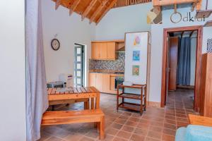 a living room with a table and a kitchen at Od Kidi Cottages in Migori
