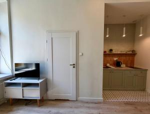 a kitchen with a door leading into a kitchen with a counter at Apartments Piotrkowska 67 in Łódź +22 photos