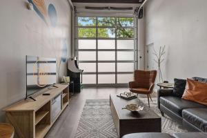 a living room with a couch and a tv at Industrial-Chic Loft-King Bed & Natural Light in Wheat Ridge