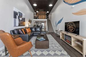 a living room with a leather couch and a fireplace at Industrial-Chic Loft-King Bed & Natural Light in Wheat Ridge