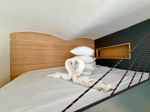 a bed with a pile of towels on it at Apartments Piotrkowska 67 in Łódź