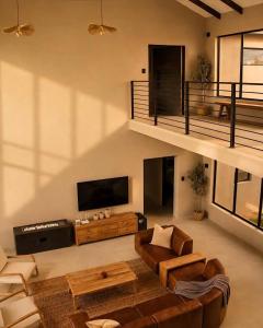 a living room with a couch and a tv at Sanyati Villa in Mmukubyane