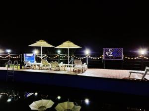a patio with tables and chairs and umbrellas at night at goheung suwan pension in Goheung +7 photos
