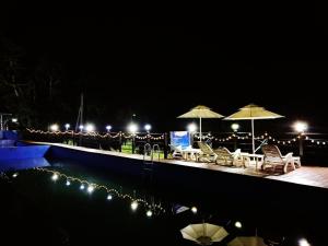 a swimming pool with chairs and umbrellas at night at goheung suwan pension in Goheung