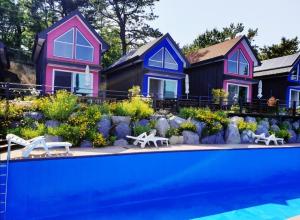 a row of colorful houses with a swimming pool at goheung suwan pension in Goheung