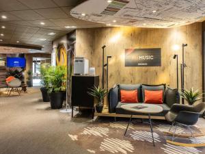 a living room with a couch and some plants at ibis Toulouse Pont Jumeaux in Toulouse