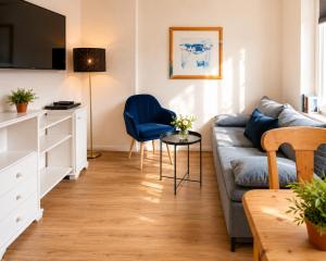 a living room with a couch and a table at CBlue "Apartmenthaus Chrischanshof" in Warnemünde