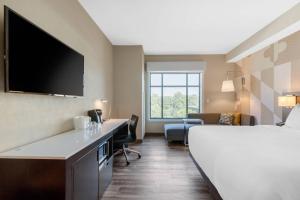 a hotel room with a bed and a flat screen tv at Cambria Hotel College Park in College Park +60 photos