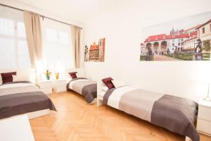 three beds in a room with a wooden floor at Fashion Loft in Prague