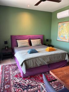 a bedroom with a large bed with a purple headboard at FinIQ Boutiq Studios in Foiníki +42 photos
