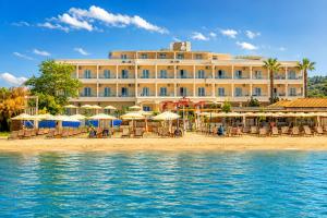 a hotel on the beach with chairs and umbrellas at Cavomarina Beach- Adults Only in Kavos