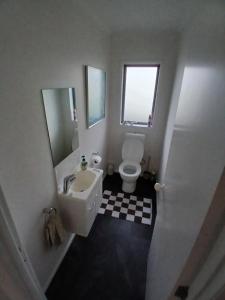 a white bathroom with a sink and a toilet at Modern Home in Central Location in New Plymouth +7 photos