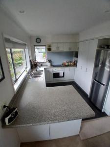 a kitchen with white cabinets and a stainless steel refrigerator at Modern Home in Central Location in New Plymouth