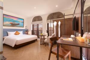 a hotel room with a bed and a desk and a table at Lumiere Boutique Vỹ Dạ in Thôn Lại Thê