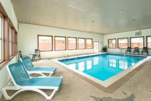 a large swimming pool with a chair and a recliner in a room at Quality Inn & Suites in Vernon