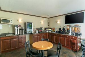 a kitchen with a table and a television and a table and chairs at Quality Inn & Suites in Vernon
