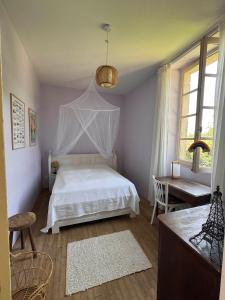 a bedroom with a white bed and a desk at Le Couvent in Lunac