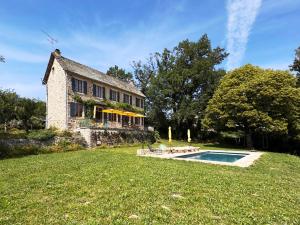 a stone house with a swimming pool in the yard at Le Couvent in Lunac