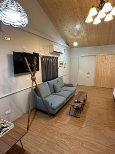 a living room with a blue couch and a table at 旅人路過時民宿 in Hsi-lo