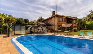 a swimming pool in front of a house at Basque Palace, Mansion con Jardín, Barbacoa, Gimnasio, Piscina, Sauna in Mungia