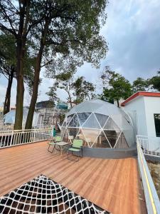 a glass dome on a deck with chairs on it at Nualam Glamping in Pasirangin