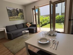 a living room with a couch and a table at Zbilje Lakeside Apartment in Medvode