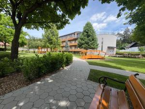 a park with a bench and a playground at Zbilje Lakeside Apartment in Medvode