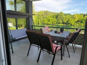 a dining room with a table and chairs on a balcony at UNA Escape in Glodina