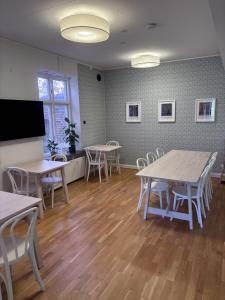 a room with tables and chairs and a flat screen tv at Minnesberg Bed & Breakfast in Trelleborg