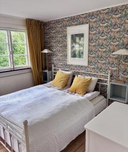 a bedroom with a large bed with yellow pillows at Minnesberg Bed & Breakfast in Trelleborg