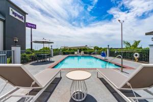 a pool with chairs and a table next to a building at Spark by Hilton Terrell in Terrell
