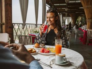 a woman sitting at a table with a plate of food at Pyramid Hotels & Resorts in Debre Zeyit