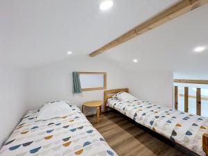 zwei Betten in einem Zimmer mit weißen Wänden in der Unterkunft Le Peage de Perouges in Pérouges
