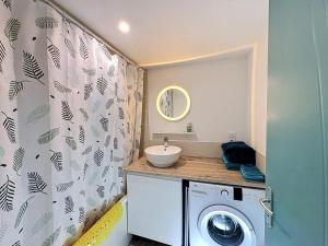 ein Badezimmer mit Waschmaschine und Waschbecken in der Unterkunft Le Peage de Perouges in Pérouges + 11 Fotos