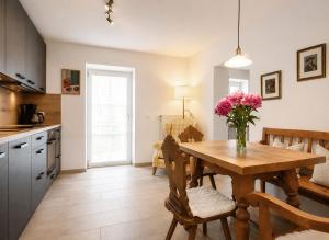 a kitchen with a table with a vase of flowers on it at Guade Stub'n Franzi in Huglfing