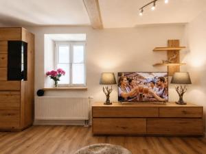 a living room with a tv and a wooden dresser at Guade Stub'n Franzi in Huglfing