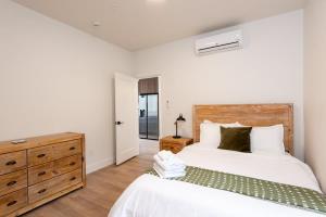 a bedroom with a large white bed and a dresser at Modern condo with town and mountain views in Evergreen