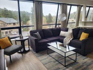 a living room with a couch and a large window at Modern condo with town and mountain views in Evergreen