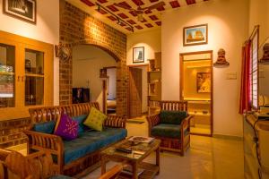 a living room with a couch and two chairs at Golden Loom Homestay in Kanchipuram