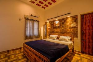 a bedroom with a bed and a brick wall at Golden Loom Homestay in Kanchipuram