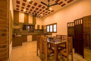 a dining room with a table and chairs in a kitchen at Golden Loom Homestay in Kanchipuram