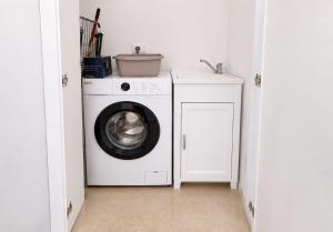 a laundry room with a washing machine and a sink at Dimora Azzurra in Pachino