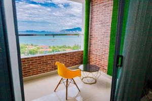 a yellow chair sitting on a balcony with a large window at Napoleon Apartment Nha Trang - Gần Biển Hòn Chồng in Nha Trang