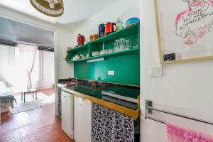 a kitchen with green cabinets and a white refrigerator at Cool charming appartment in historic forcalquier in Forcalquier