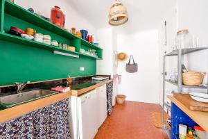 a kitchen with green shelves and a sink at Cool charming appartment in historic forcalquier in Forcalquier